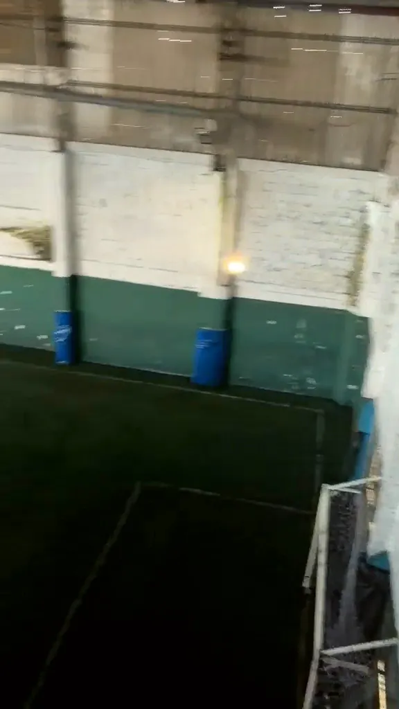 Cancha cubierta vista desde arriba, con arco y protecciones azules en las paredes