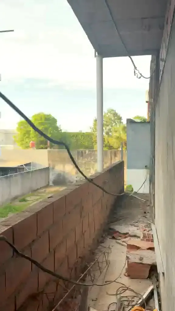 Balcón de la planta alta con muro de ladrillo y vista a la arboleda